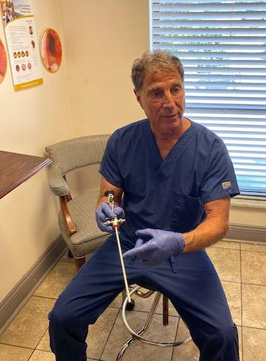 Dr. Michael Pelekanos, a urogynecologist with Penn Highlands Healthcare, explains to a patient how he uses a cystoscope to view the inside of her bladder.