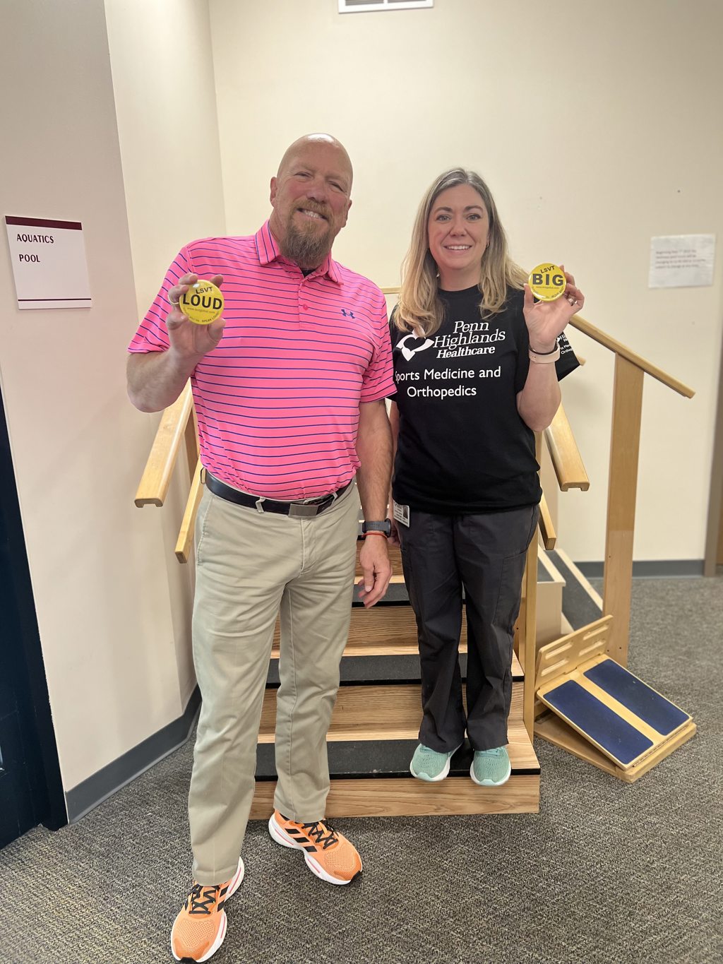 Mark Seaton, ST, a speech therapist, and Christine Ritchey, MOT, OTR/L, an occupational therapist, display buttons promoting LSVT Loud and LSVT Big at The Rehabilitation Center in Huntingdon.